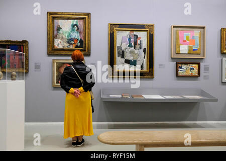 Die Besucher der Tate St. Ives, Cornwall, Großbritannien, an Gemälde, darunter "Compotier, Violine, Boutelle schauen" von Picasso (schwarzer Rahmen). Stockfoto