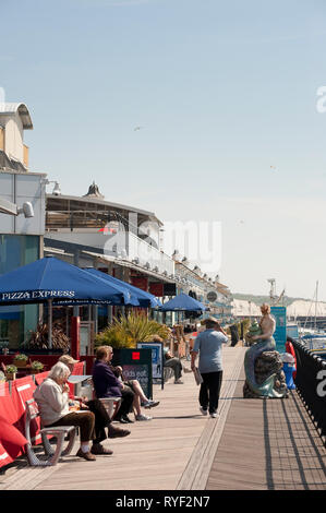 Die Leute draußen sitzen Restaurants in Brighton Marina, Sussex, England. Stockfoto