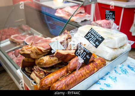 Große Stapel von ganzen Speck. Große geräuchertem Speck. Geräucherte Wurst. Gesalzenen Schmalz. Inschrift auf russisch: geräucherter Speck, Krakauer Wurst. Stockfoto