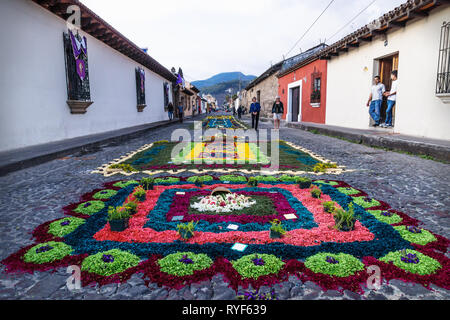 Antigua, Guatemala - 23 März 2018: Menschen bei Alfombre bunte Blume Teppiche auf den gepflasterten Straßen Stockfoto