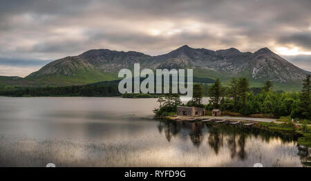 Lough Inagh in Irland mit einer Kabine und Boote am See Stockfoto