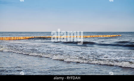 Panoramablick auf ein Meer aus Holz Wellenbrecher bei Sonnenaufgang. Stockfoto