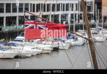 Eine Fahne im Wind auf dem Mast eines Schiffes in der Bristol Dock, Großbritannien. Stockfoto