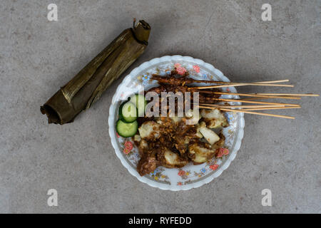 Chicken Satay mit Reis Kuchen (lontong), Street Food, die Sie überall in der Indonesischen Straße zu finden. Stockfoto