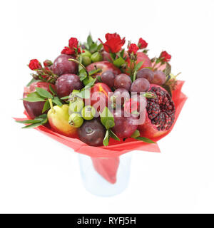 Genießbare Blumenstrauß aus Granatapfel, Äpfel, Pflaumen und roten Rosen in einer Vase auf weißem Hintergrund stehend Stockfoto