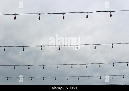 Unlit Lichterketten über eine Straße gespannt auf ein trüber Tag. Stockfoto