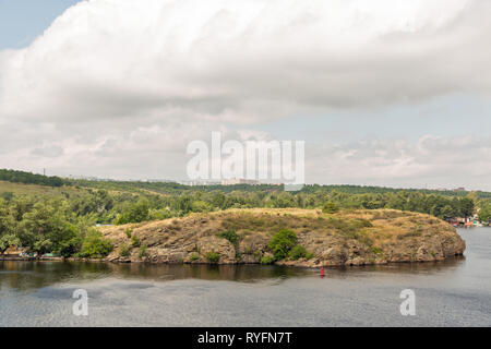 Landschaft mit Saporoshje Stadtbild in der Ferne und Khortytsia, der größten Insel des Flusses Dnjepr, der Ukraine. Stockfoto