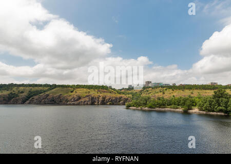 Landschaft mit Saporoshje Stadtbild in der Ferne und Khortytsia, der größten Insel des Flusses Dnjepr, der Ukraine. Stockfoto