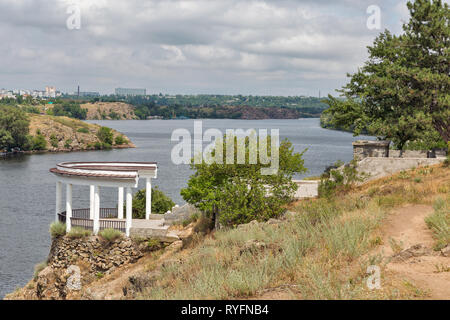 Landschaft mit Säulengang, Saporoshje Stadtbild in der Ferne und Khortytsia, der größten Insel des Flusses Dnjepr, der Ukraine. Stockfoto