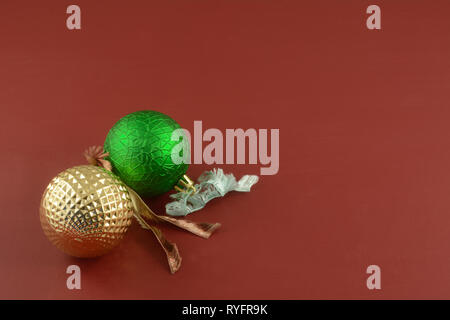 Rot und gold Christmas Ball Ornamente mit Ribbon Bindungen auf rotem Hintergrund Stockfoto