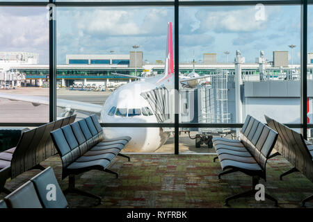 Leere Stühle in der Abflughalle am Flughafen mit dem Flugzeug parken. Reise und Verkehr in Flughafen-Konzepte. Stockfoto