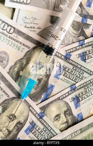Nahaufnahme der Spritze mit Einspritzung in Dollar Banknoten Stockfoto