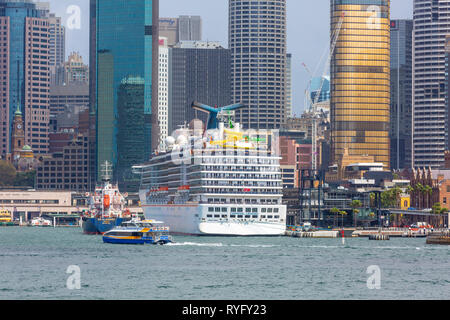 Carnival Legend Kreuzfahrt Schiff vertäut am Circular Quay und Blick auf Sydney Office Center und Hochhäuser, Sydney, Australien Stockfoto