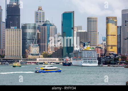 Carnival Legend Kreuzfahrt Schiff vertäut am Circular Quay und Blick auf Sydney Office Center und Hochhäuser, Sydney, Australien Stockfoto