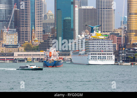 Carnival Legend Kreuzfahrt Schiff vertäut am Circular Quay und Blick auf Sydney Office Center und Hochhäuser, Sydney, Australien Stockfoto