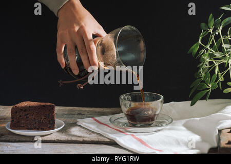 Man gießt kalten Kaffee brühen in Glas auf dem Tisch Stockfoto