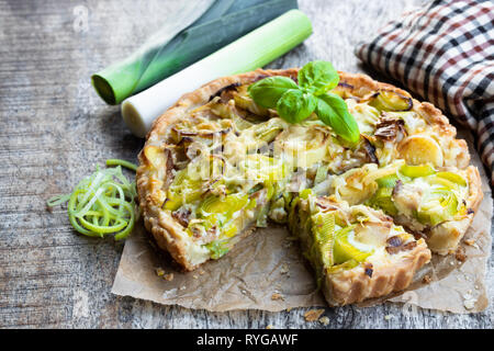 Tarte mit Speck und Käse auf dem Holztisch Stockfoto