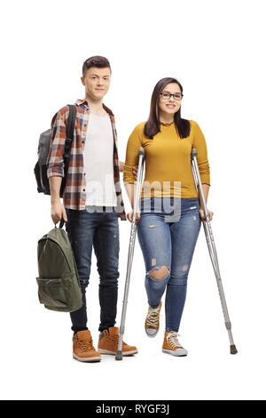In voller Länge Porträt einer männlichen Kursteilnehmer helfen ein weiblicher Kursteilnehmer gehen mit Krücken auf weißem Hintergrund Stockfoto
