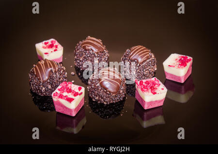 Schokolade Pralinen, dekoriert mit roten bonbones. Stockfoto
