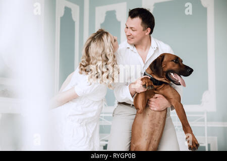 Glückliche Familie und ihren Haustieren Ridgeback in einem modernen Apartment. Stockfoto