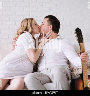 Küssen Paar sitzen auf der Couch in ein gemütliches Wohnzimmer Stockfoto