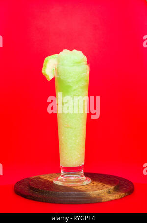 Grüne Guave Smoothie in Glas mit Guave Obst auf rotem Hintergrund, gesunden Entgiftung oder Diät Konzept Stockfoto