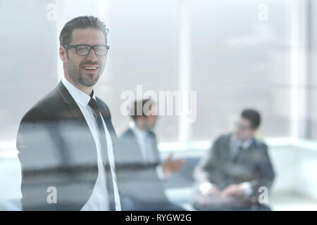 Zuversichtlich Geschäftsmann auf der Suche durch das Büro Fenster Stockfoto