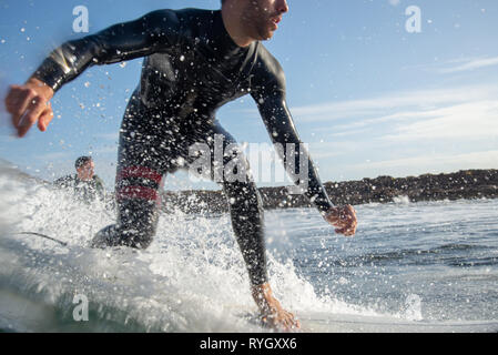 Fuerteventura - März 01, 2019: Surfer reiten Wellen auf der Insel Fuerteventura im Atlantischen Ozean Stockfoto