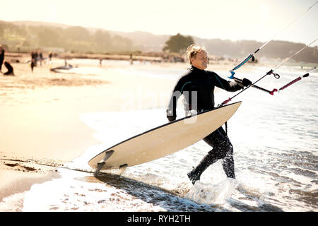 Mitte der erwachsene Mann Kitesurfen in der Nähe der Golden Gate Bridge, San Francisco, USA. Stockfoto