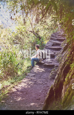 Ein Mann mit Rucksack auf Stein Straße Cliff Stockfoto