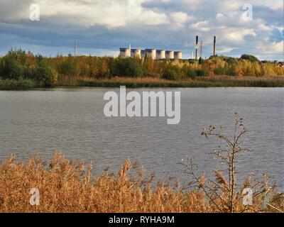 Blick über den Fluss Aire von Fairburn Ings Nature Reserve, West Yorkshire, England, mit den Türmen von Ferrybridge Power Station im Hintergrund Stockfoto