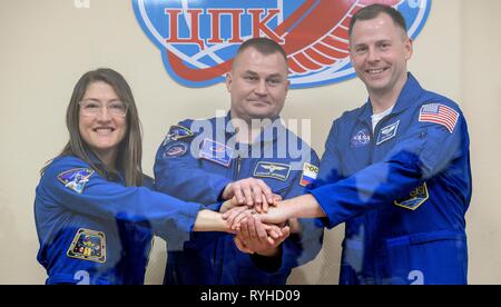 Internationale Raumstation ISS Expedition 59 prime Crew Mitglieder Christina Koch der NASA, Links, Alexey Ovchinin von Roskosmos, und Nick Haag der NASA, rechts, für ein Foto auf den Abschluss einer Pressekonferenz aus der Quarantäne auf dem Kosmodrom Baikonur Kosmonaut Hotel March 13, 2019 in Baikonur, Kasachstan dar. Expedition 59 Besatzung: Christina Koch der NASA, Alexey Ovchinin von Roskosmos, und Nick Haag der NASA startet 14. März an Bord der Sojus MS-12 Raumfahrzeug für eine sechs-und-ein-halb Monat Mission auf der Internationalen Raumstation. Stockfoto