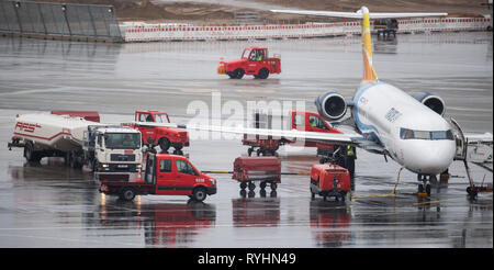 Hamburg, Deutschland. 14 Mär, 2019. Das Bodenpersonal arbeiten an einer Fokker F 100 Flugzeugen der Fluggesellschaft Handel Luft auf dem Vorfeld des Flughafen Hamburg. Die Gewerkschaft Verdi ruft zu Warnstreiks Bodenpersonal des Flughafens. Credit: Daniel Reinhardt/dpa/Alamy leben Nachrichten Stockfoto