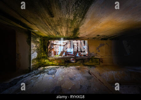 Verloren Platz Verlassen der Halle mit kaputtem Dach und Moos und Schimmel an der Wand im alten Hotel im Ferienort Sistiana in der Nähe von Triest in Italien Stockfoto