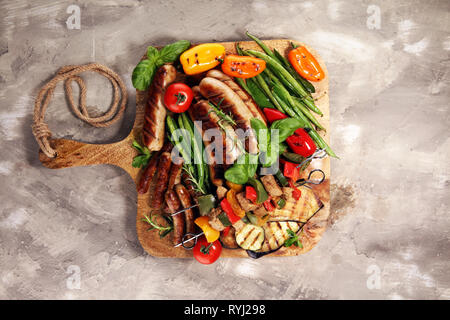 Verschiedene köstliche gegrillte Fleisch mit Gemüse auf einem Grill und gegrilltem Schweinefleisch oder Shish Kebab am Spieß mit Gemüse. Stockfoto