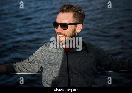 Schöner Mann ruht auf Yachtcharter in das offene Meer auf Kreuzfahrt Stockfoto