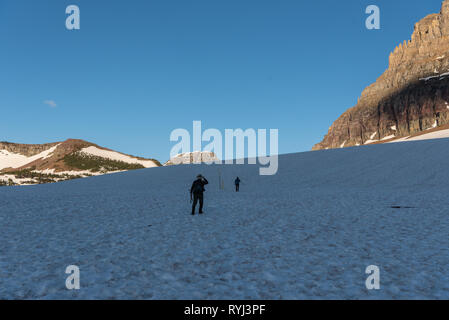 Zwei Wanderer auf einem schneebedeckten Logan Pass wanderung heraus zu versteckten See Stockfoto