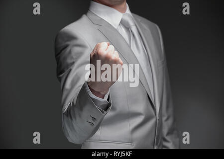 Bis zu schließen. Geschäftsmann ballte seine Hand zu einer Faust. auf schwarzem Hintergrund Stockfoto