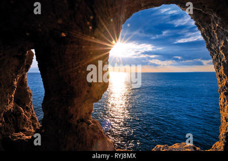 Romantischer Sonnenuntergang durch eine Rock arch gesehen Stockfoto