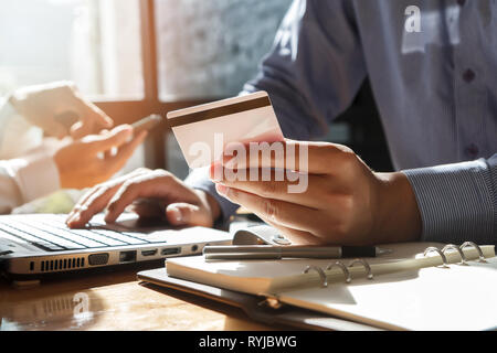 Unternehmer, die Kreditkarte und mit Laptop. Die Zahlung beim Online shopping. E-Commerce und moderne Technik Konzept Stockfoto
