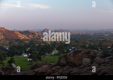 Die Felsbrocken von Hampi mit virupaksha Temple bei Sonnenuntergang in Hampi Stockfoto