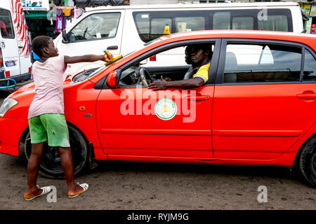 Junge Reinigung Auto Windschutzscheibe im Verkehr in Yopougon, Abidjan, Elfenbeinküste. Stockfoto