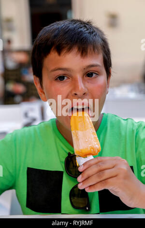12-jähriger Junge essen ein Eis in Syrakus, Sizilien (Italien). Stockfoto