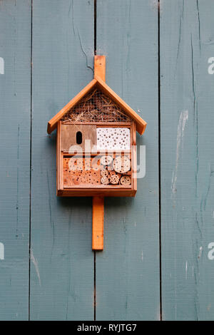 Insecthotel in einem orange Haus auf eine Holzwand Stockfoto