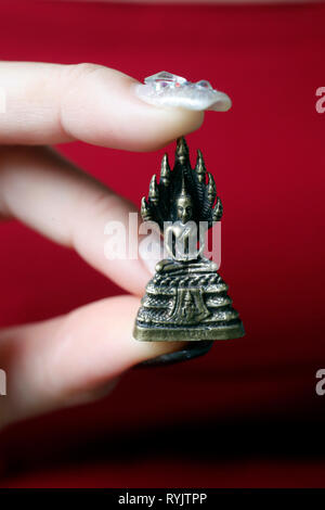 Frau mit einer Miniatur Figur Messing Statue von Buddha mit 7 Köpfen Naga. Ho Chi Minh City. Vietnam. Stockfoto