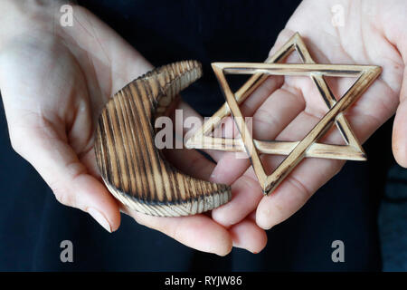 Islam und Judentum. Jüdische David Stern und muslimische Halbmond: Interreligiöses Symbole in Händen. Stockfoto