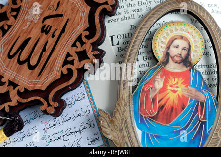 Kuran und Bibel mit Allah Monogramm und Jesus heiligen Herzen. Interreligiöse Symbole. Vung Tau. Vietnam. Stockfoto