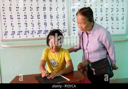 Zentrum für blinde Kinder von Kindern Aktion ausführen. Mädchen schreiben Blindenschrift. Ho Chi Minh City. Vietnam. Stockfoto