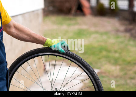 Man Kontrolle Fahrrad Reifen Luftdruck für die Saison Stockfoto