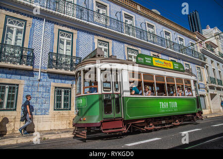 Straßenbahn vorbei vor eines Gebäudes mit Azulejo, in einer Straße von Lissabon, Portugal Stockfoto